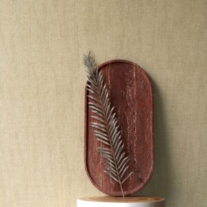 Decoratieve opstelling met een roodbruine schaal en een zilverkleurig blad tegen een beige Arte Manila Tulle 73080A behang.