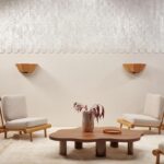 Moderne zithoek met licht houten meubels, een organisch gevormde salontafel en een glanzend ARTE Luster Abalone 70320 wandpaneel.