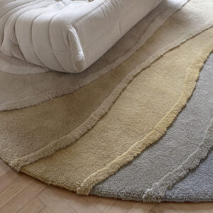 Beige Allegro High AERH32877 vloerkleed met gelaagd patroon onder een lichtgekleurde moderne fauteuil op houten vloer.