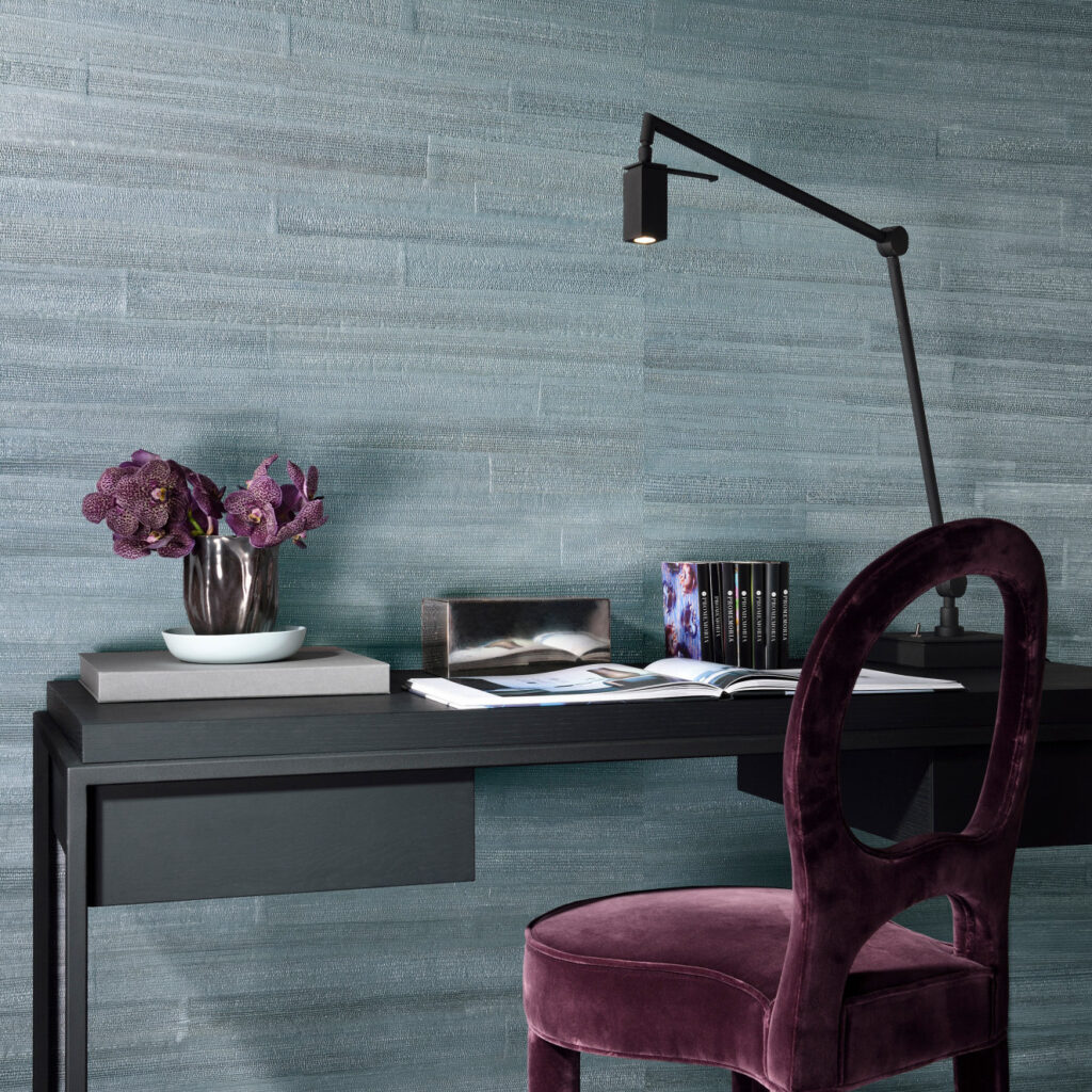 Moderne werkplek met Arte All Naturals Camago 14006 behang in blauwgroene tinten, zwarte schrijftafel en paarse fluwelen stoel.