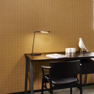 Zwarte designwerkplek met zwarte stoel, moderne bureaulamp en Arte Atelier Alma behang in mosterdgeel met subtiel rasterpatroon.