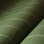 Detailopname van groen Arte Atelier Alma1 textiel met een geometrisch gestikt patroon.