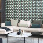 Moderne zithoek met lichtbeige hoekbank, gekleurde kussens en een geometrisch patroonbehang uit de Arte Atelier Cosma collectie.