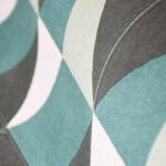 Close-up van het geometrische patroon van het Arte Atelier Cosma2 behang in grijs, wit en turquoise.