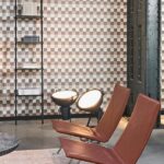 Interieur met leren designstoelen, industriële lampen en een wand met geometrisch Arte Atelier Plaza2-behang.