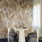 Moderne zithoek met Arte Chintz behang uit de Essentials Les Tricots collectie in warme aardetinten en bladpatroon.