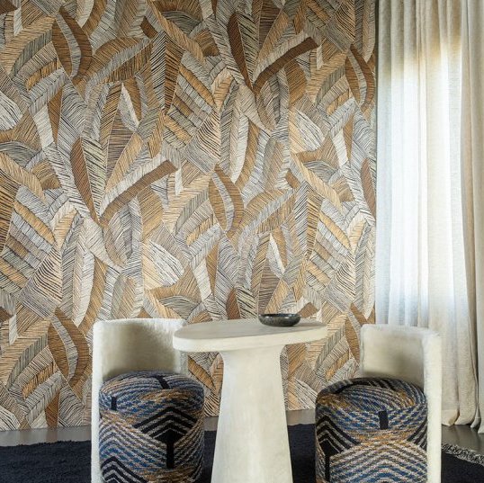 Moderne zithoek met Arte Chintz behang uit de Essentials Les Tricots collectie in warme aardetinten en bladpatroon.