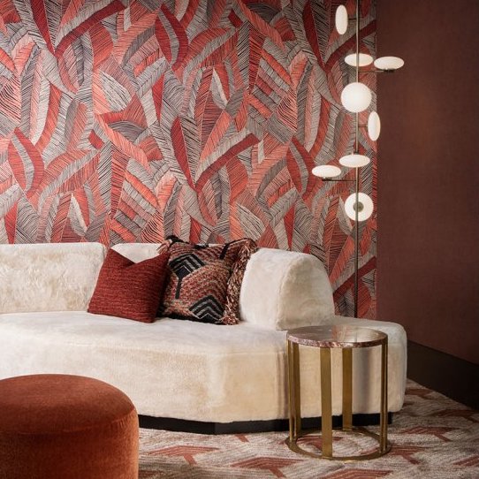 Moderne woonkamer met Arte Chintz-behang uit de Essentials Les Tricots collectie, crèmekleurige bank, ronde bijzettafel en design hanglamp.