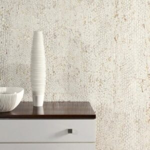Moderne witte kast met houten blad, versierd met een geribbelde vaas en schaal, tegen een Arte Cobra-CA02 muur met slangenhuidstructuur.