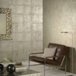 Stijlvolle zithoek met een leren fauteuil, moderne verlichting en metallic Arte Cobra CA3 wandbekleding.