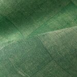 Groen behang met een textielachtige structuur en patchwork-patroon uit de Arte Cuadro Gitane collectie.