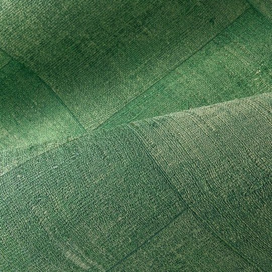 Groen behang met een textielachtige structuur en patchwork-patroon uit de Arte Cuadro Gitane collectie.