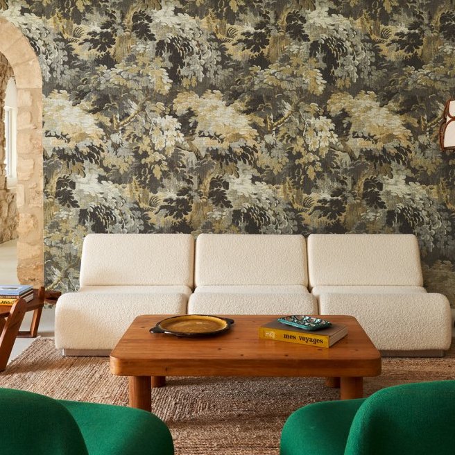 Sfeervolle woonkamer met Arte Diore 48010 behang uit de Les Forêts collectie, een crèmekleurige bank en houten salontafel.