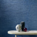 Marmeren tafel met drie decoratieve vazen tegen blauw Arte Drift behang in een moderne woonkamer.