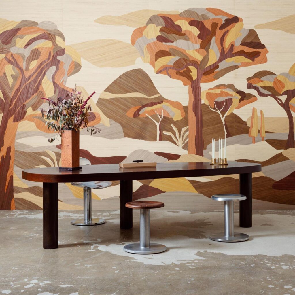 Moderne eettafel met krukken voor een wand met kleurrijk, kunstzinnig boslandschap uit de serie "Under The Sycamore Tree" van Arte Embleme.