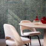 Moderne eethoek met beige stoelen, ronde houten tafel en Arte Essentials Tangram Intarsio 24041 behang met geometrisch patroon.