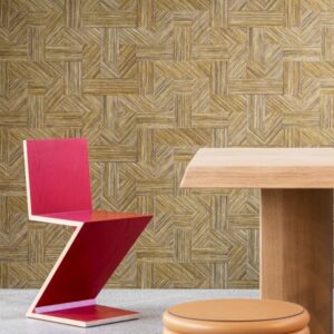 Moderne interieursetting met Arte Essentials Tangram Intarsio 24040 behang, een roze Z-stoel, houten tafel en ronde poef.