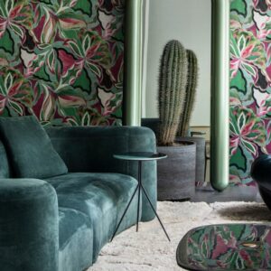 Moderne woonkamer met groenfluwelen bank, grote cactusplant, spiegel en kleurrijk Arte Essentials Tangram Myriad 24100 behang.