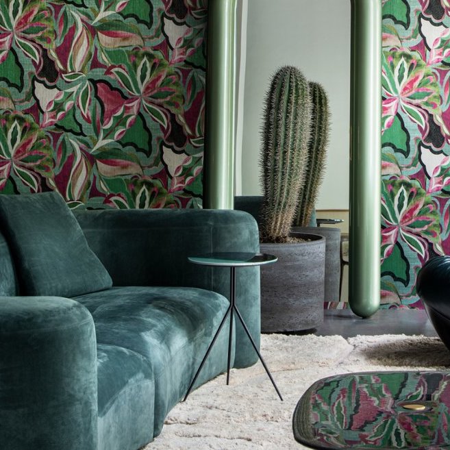 Moderne woonkamer met groenfluwelen bank, grote cactusplant, spiegel en kleurrijk Arte Essentials Tangram Myriad 24100 behang.