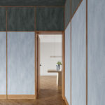 Moderne woonkamer met Arte Essentials Washed Linen behang in blauwgrijze tinten en houten accenten.