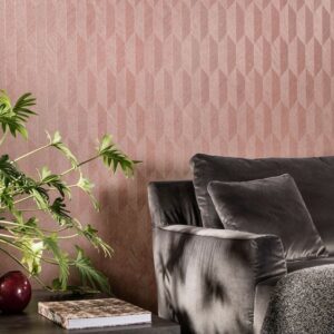 Grijze fluwelen bank met sierkussen tegen een roze geometrisch Arte Focus Symbol-26533 behang, naast een plant en bijzettafel.