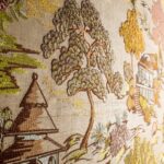 Detailopname van het Arte Gardens of Okayama behang met een Japans geïnspireerd tuinlandschap in borduureffect.