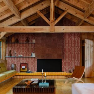 Sfeervol interieur met een houten plafond, een open haard met Arte Icarus Indomito wandbekleding en retro-meubels.