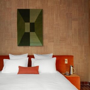 Modern ingerichte slaapkamer met een roodfluwelen bed, witte kussens, het Arte Icarus Telaio 15721 wandpaneel en een houten nachtkastje met een gouden karaf.