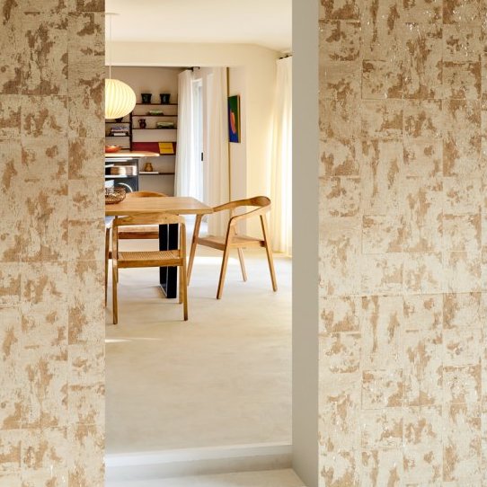Doorkijk naar een eetkamer met houten meubelen en Arte Eclat 48011 White Patina Les Forêts behang op de muur.
