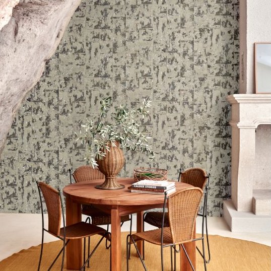 Eettafel met rotan stoelen voor een muur met Arte International Éclat 48042 Smoke Les Forêts behang in een natuurlijke setting.