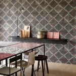 Interieur met Arte Janela-behang uit de Gitane-collectie in een geometrisch patroon, gecombineerd met een moderne eettafel en decoratieve objecten op een zwevende plank.