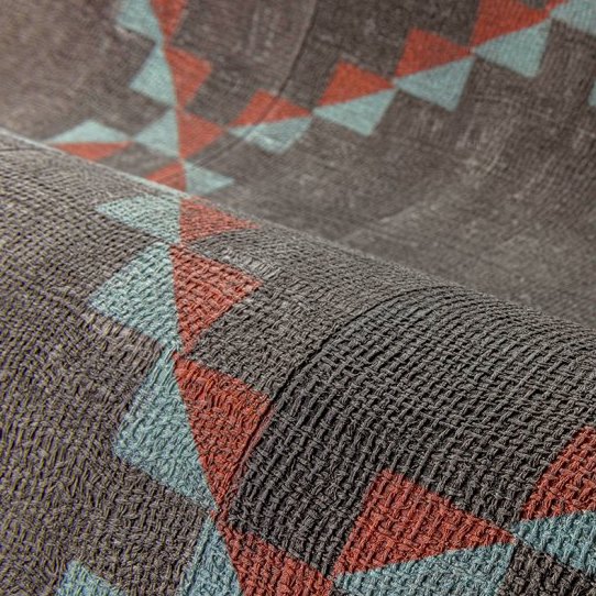 Close-up van het Arte Janela behang uit de Gitane collectie met een geometrisch patroon in rood, blauw en grijs.