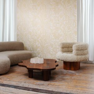 Een modern interieur met een beige Arte Joie 30810-behang, zachte designmeubels en een organisch gevormde houten salontafel.