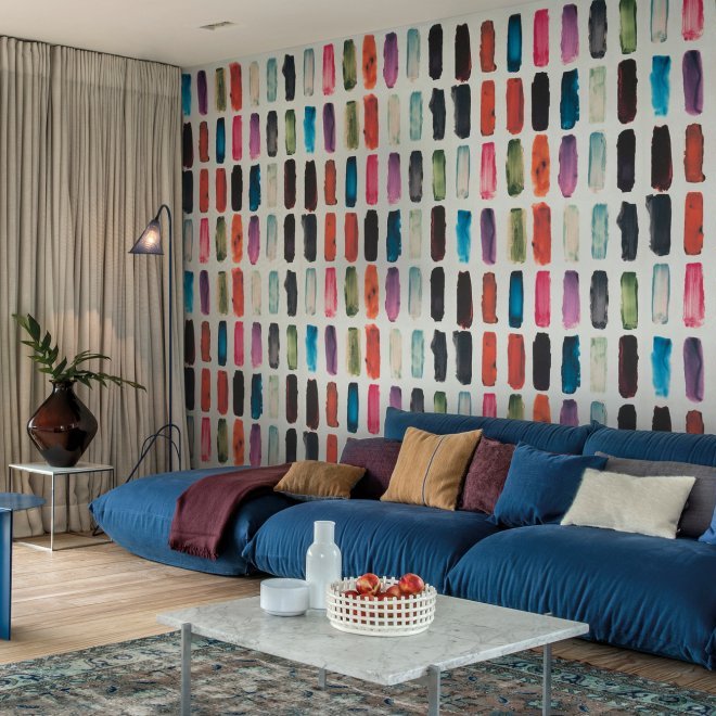 Moderne woonkamer met een kleurrijk Arte Joy Zest JOY71 behang en een groot blauw loungebankstel.