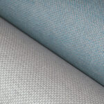 Detailopname van twee rollen geweven Arte Ligna Scope wandbekleding in grijs en blauw.