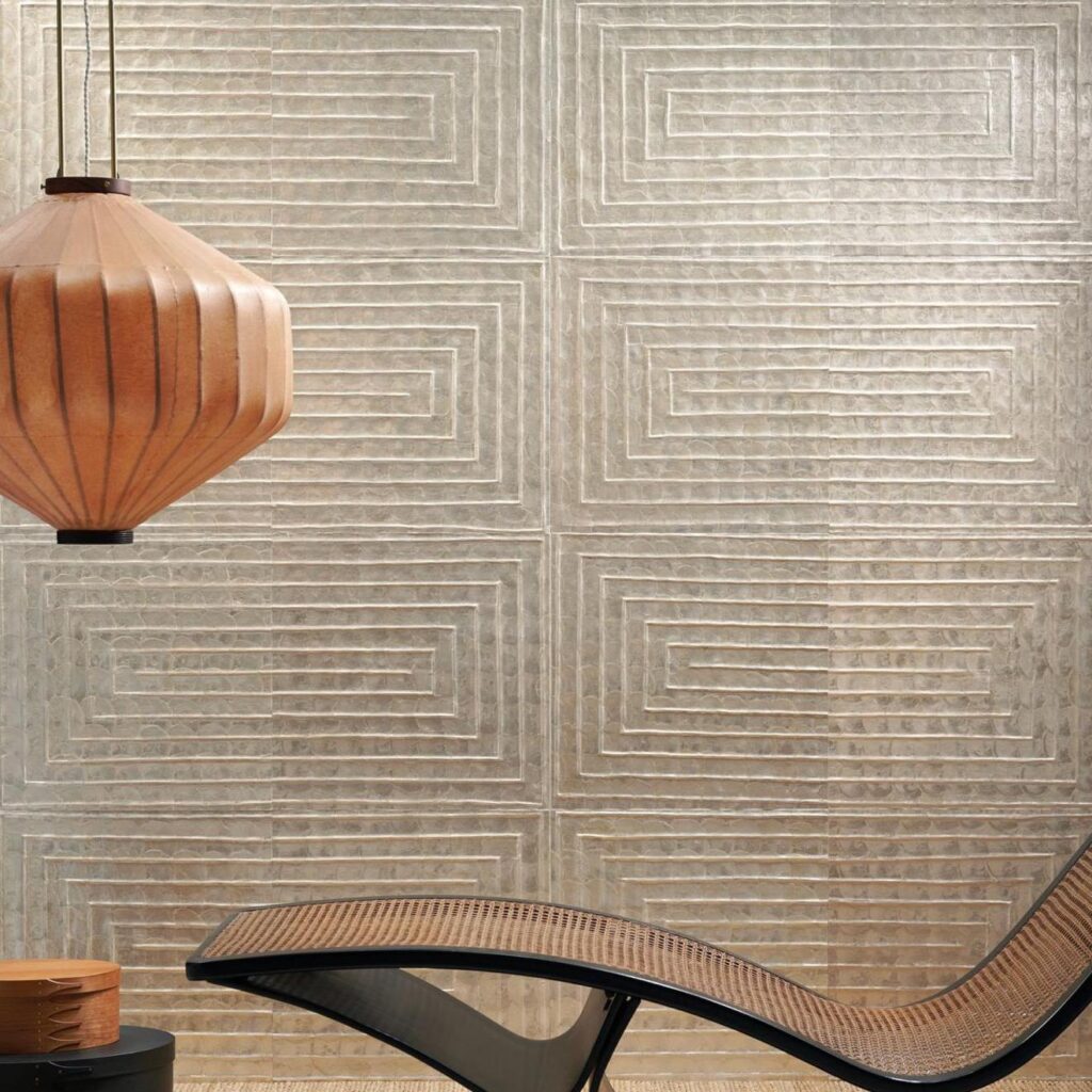 Moderne interieursetting met Arte Luster Cornice 70331 wandbekleding, een houten hanglamp en een gebogen loungestoel.
