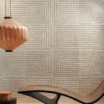 Moderne interieursetting met Arte Luster Cornice 70331 wandbekleding, een houten hanglamp en een gebogen loungestoel.