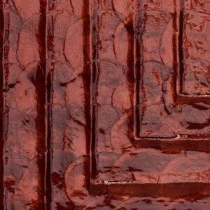 Detailopname van de glanzende rode textuur en reliëfstructuur van de Arte Luster Cornice 70333 Garnet wandbekleding.