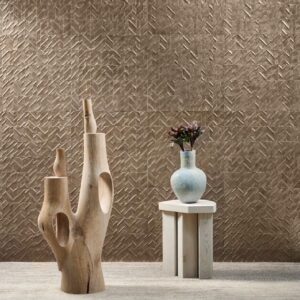 Moderne interieursetting met Arte Luster Perula 70302 wandbekleding, een houten sculptuur en een vaas met takken op een houten tafeltje.