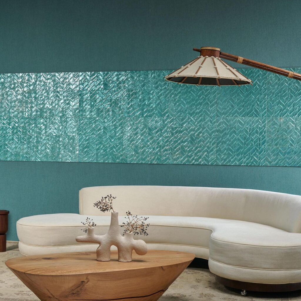 Moderne zithoek met een gebogen crèmekleurige bank, houten salontafel en Arte Luster Perula 70303 wandbekleding in turquoise.