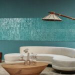 Moderne zithoek met een gebogen crèmekleurige bank, houten salontafel en Arte Luster Perula 70303 wandbekleding in turquoise.