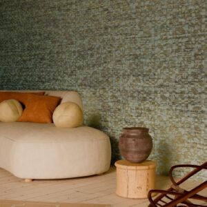 Zithoek met beige chaise longue, ronde kussens en aardewerken vaas voor een wand met Arte Marquesa Cyperus behang.