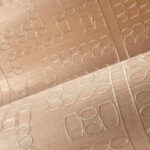 Detail van de Arte Marquesa Taio 31714 stof met een ingeweven geometrisch patroon in beige tinten.