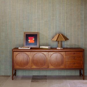 Mid-century dressoir tegen een muur met Arte Melaky Farini 40724-behang in een rustieke, geweven textuur.