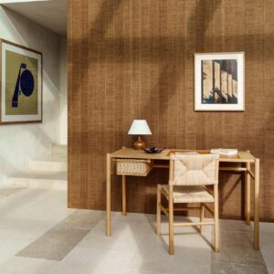Minimalistisch houten bureau met rieten stoel en tafellamp tegen een wand bekleed met Arte Melaky Farini 40726 behang.