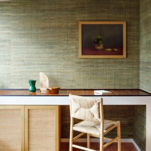 Sfeervol interieur met Arte Melaky Tana behang, een houten bureaustoel en kunstwerk met citrusvruchten aan de muur.