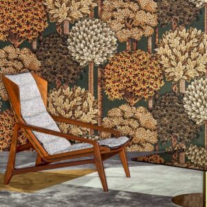 Houten loungestoel met grijze bekleding voor een wand met kleurrijk boompatroon uit de Arte MontRoyal behangcollectie.