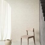 Minimalistisch interieur met Arte Pampas Cupula behang, houten stoel, keramische vaas en lichte gordijnen.