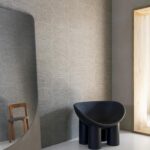 Moderne woonkamer met Arte Pampas Cupula behang, een zwarte designstoel en een grote spiegel.