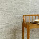 Houten tafel met keramische schaal tegen een wand met Arte Pampas Cupula behang met lichtgrijs patroon.